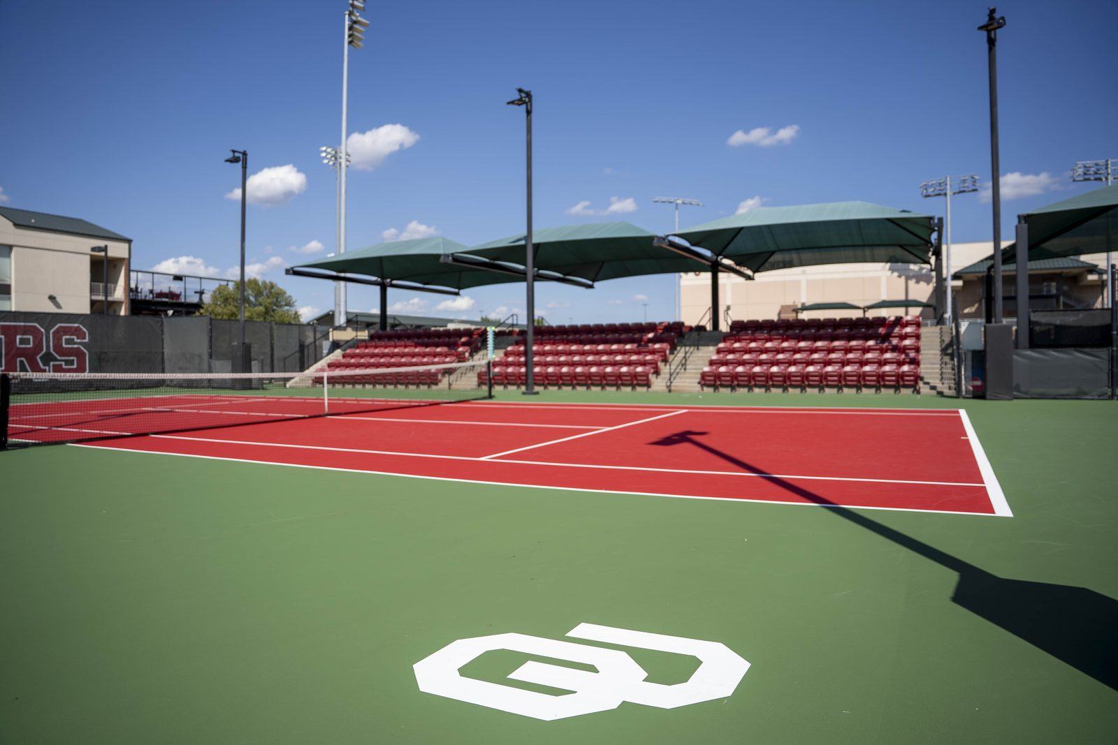 OU logo stenciled on a green court surround at Headington Tennis Center