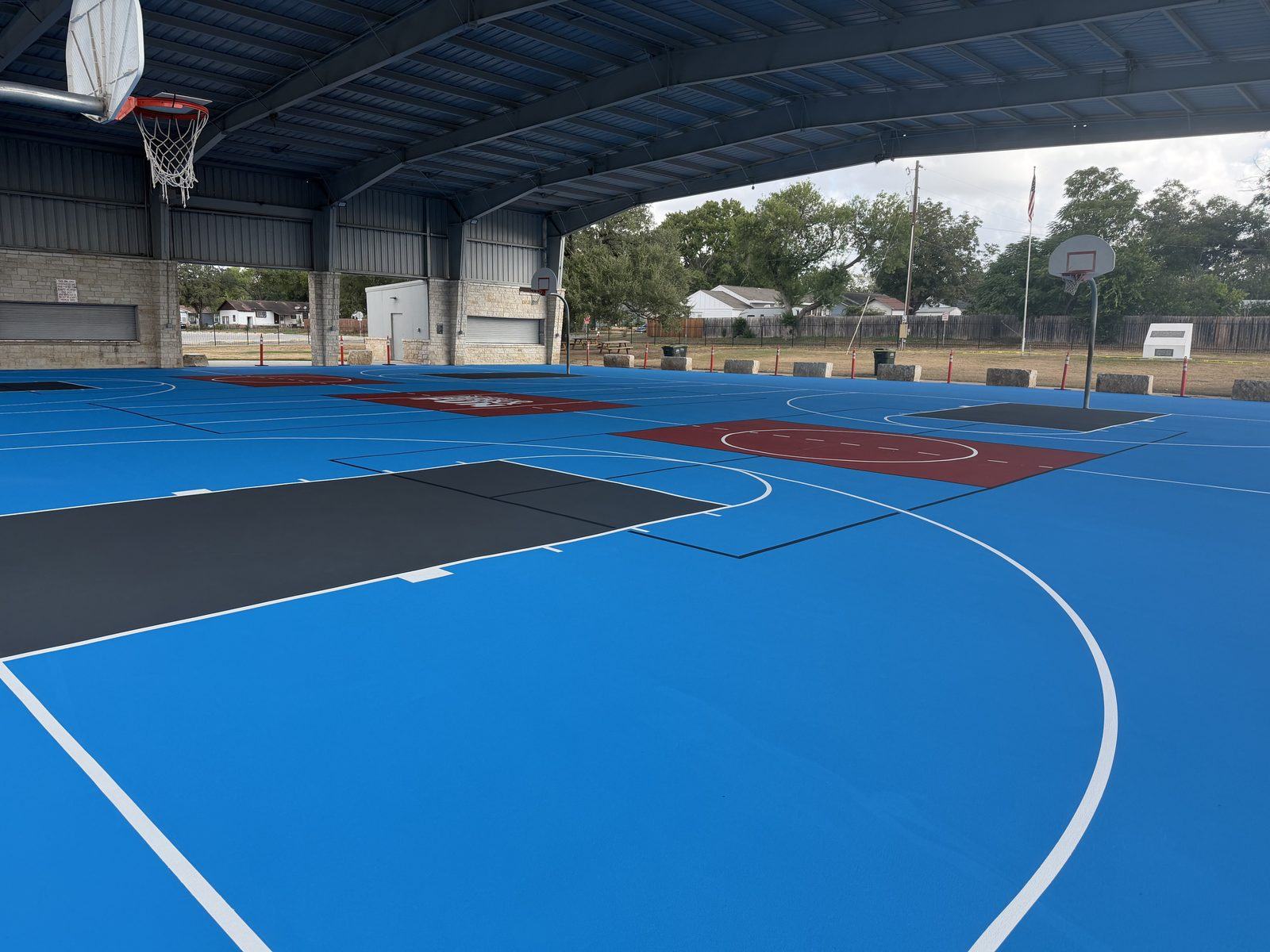 Three pickleball courts with light blue field and brick red kitchens at Pickrell Park